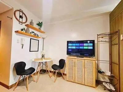a living room with two chairs and a television at Sabrina Staycaytion in Manila
