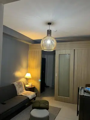 a living room with a couch and a lamp at Bay stays at shore residence in Manila