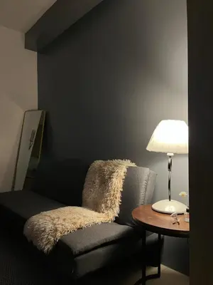 a room with a chair and a table with a lamp at Bay stays at shore residence in Manila