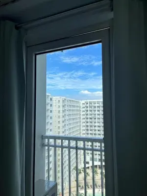 a window with a view of a large building at Bay stays at shore residence in Manila