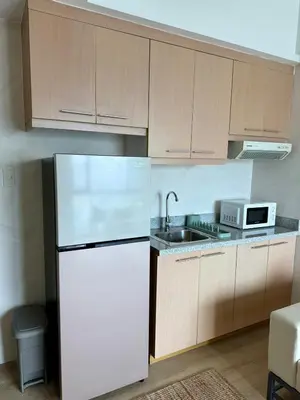 a kitchen with a white refrigerator and a microwave at Condo Roughly 30 mins from NAIA with view of Greenhills in Manila