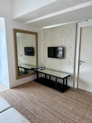 a living room with a table and a mirror at Condo Roughly 30 mins from NAIA with view of Greenhills in Manila