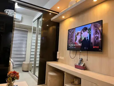 a flat screen tv on a wall in a room at EaseStay by Bren in Shell Residences MOA in Manila
