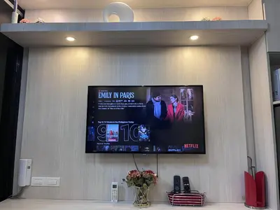 a flat screen tv hanging on a wall at EaseStay by Bren in Shell Residences MOA in Manila
