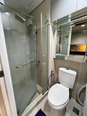 a bathroom with a toilet and a glass shower at EaseStay by Bren in Shell Residences MOA in Manila