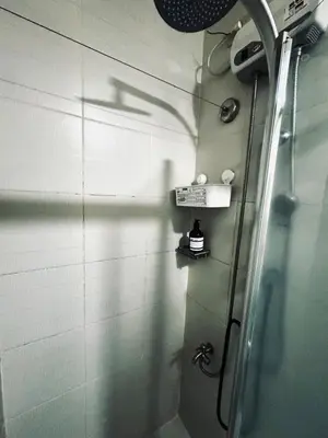 a bathroom with a shower and a shadow on the wall at Exquisite 2 Bedroom Suite in Manila