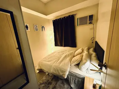 a small bed in a room with a window at Exquisite 2 Bedroom Suite in Manila