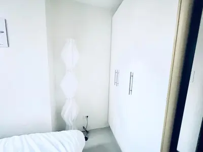 a white room with a bed and a mirror at Exquisite 2 Bedroom Suite in Manila