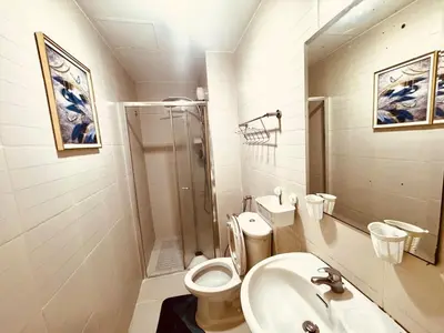 a bathroom with a toilet and a sink and a shower at Exquisite 2 Bedroom Suite in Manila