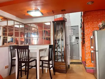 a kitchen with a table and chairs and a refrigerator at Pahingahan in Cainta