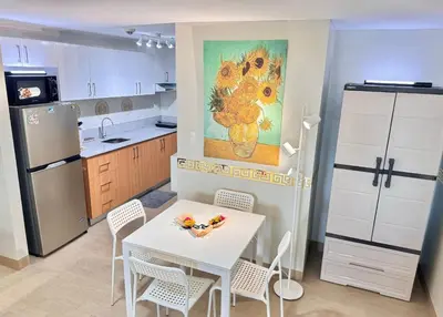 a kitchen with a table and chairs and a refrigerator at Manhattan's Place in Manila
