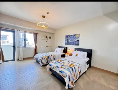 a bedroom with two beds and a chandelier at Manhattan's Place in Manila