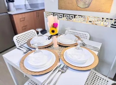 a table with white plates and a sunflower on it at Manhattan's Place in Manila