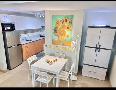 a kitchen with a table and chairs and a refrigerator at Manhattan's Place in Manila