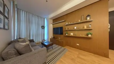 a living room with a couch and a tv at Full-Serviced Residential Apartment in Blue Sapphire, BGC in Manila