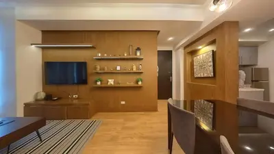 a living room with a table and a television at Full-Serviced Residential Apartment in Blue Sapphire, BGC in Manila