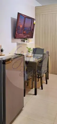 a dining room with a table and a tv on the wall at 10th Floor Facing Amenity in Manila