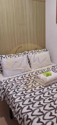 a bed with a black and white comforter and pillows at 10th Floor Facing Amenity in Manila