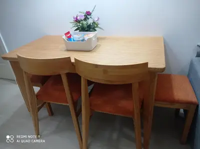 a wooden table with two chairs and a bowl of flowers at Azure Condo by arlene in Manila