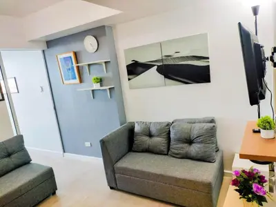 a living room with a couch and a tv at Azure Condo by arlene in Manila