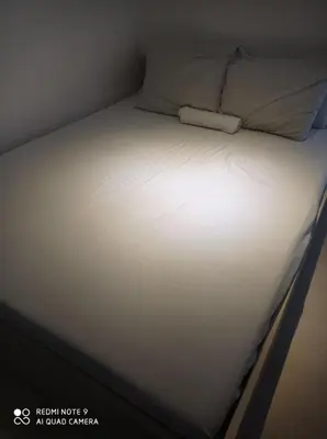 a bed with white sheets and a pillow on it at Azure place by arlene in Manila