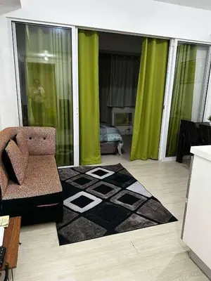 a living room with a chair and a rug at Azure Urban Resort by Tallia & Tiffany in Manila