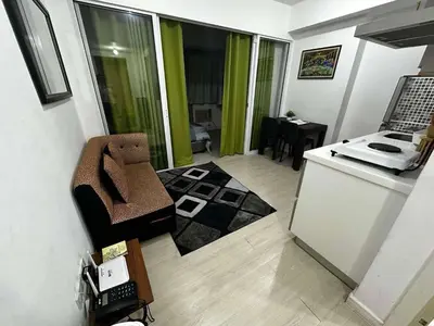 a room with a kitchen with a counter and a table at Azure Urban Resort by Tallia & Tiffany in Manila