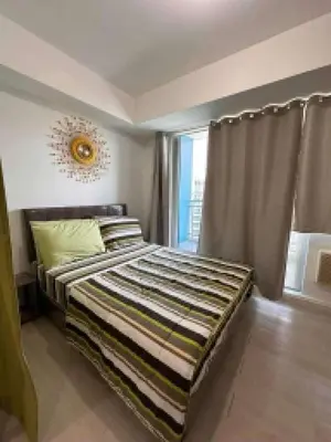 a bedroom with a bed and a large window at Azure Urban Resort by Tallia & Tiffany in Manila