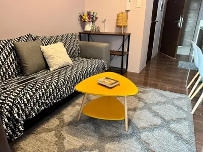 a living room with a couch and a yellow table at City Bliss Chill Vibes Makati 5338 Netflix Swim Gym Park Superfast Net in Manila