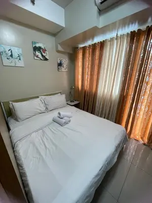 a bedroom with a white bed and a window at 1bedroom Pool view 1441 shell residence with balcony in Manila