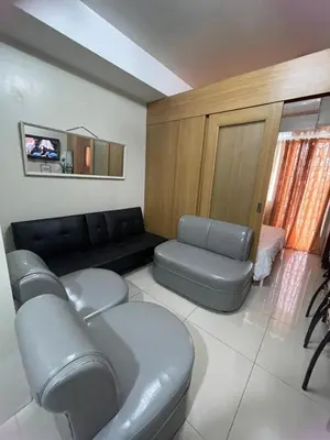 a living room with a couch and a table at 1bedroom Pool view 1441 shell residence with balcony in Manila