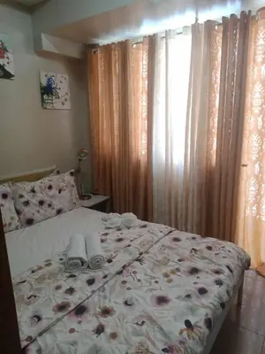 a bedroom with a bed with flowers on it at 1bedroom Pool view 1441 shell residence with balcony in Manila