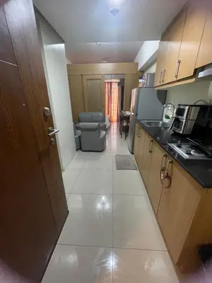a small kitchen with a sink and a couch at 1bedroom Pool view 1441 shell residence with balcony in Manila