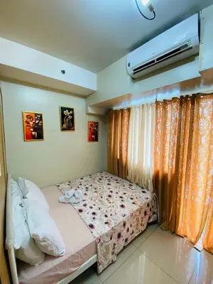 a bedroom with a bed and a air conditioner at 1bedroom Pool view 1441 shell residence with balcony in Manila