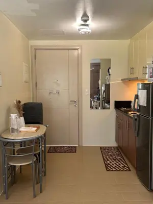 a small kitchen with a table and a refrigerator at The Chic Studio at 150 Near NAIA Terminal 3 in Manila