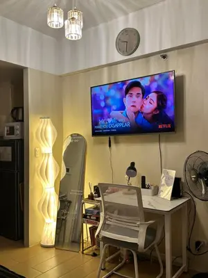 a living room with a table and a tv on the wall at The Chic Studio at 150 Near NAIA Terminal 3 in Manila