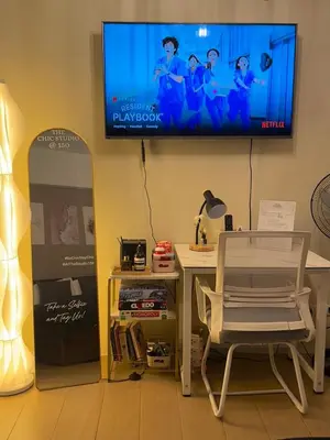 a living room with a chair and a tv on the wall at The Chic Studio at 150 Near NAIA Terminal 3 in Manila