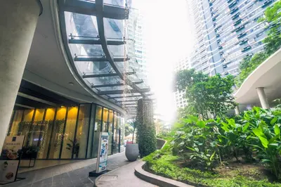 a building with a hallway with plants and buildings at Air Dream Den Good Vibes Makati Gym Swim Park Superfast Internet 3870 in Manila