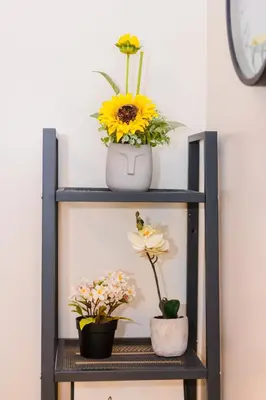a shelf with two vases and flowers on it at Air Dream Den Good Vibes Makati Gym Swim Park Superfast Internet 3870 in Manila
