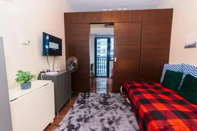 a hotel room with a bed and a tv and a room at Air Dream Den Good Vibes Makati Gym Swim Park Superfast Internet 3870 in Manila