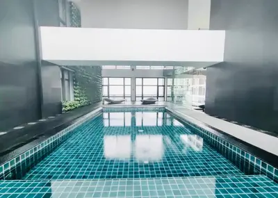 a swimming pool with blue tiles in a building at The Gramercy Residences NEW Sleek 1BR Suite, 600mbps Wifi, Netflix & FREE Amenities in Manila