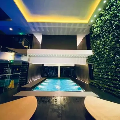 a large swimming pool in a building with a wall at The Gramercy Residences NEW Sleek 1BR Suite, 600mbps Wifi, Netflix & FREE Amenities in Manila