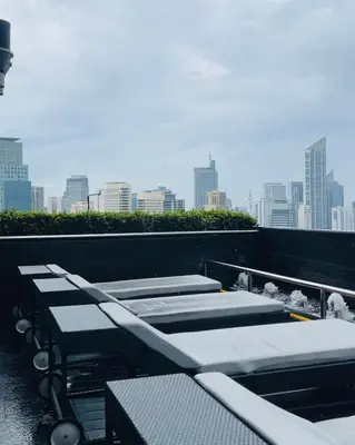 a row of chaise lounges on the roof of a building at The Gramercy Residences NEW Sleek 1BR Suite, 600mbps Wifi, Netflix & FREE Amenities in Manila