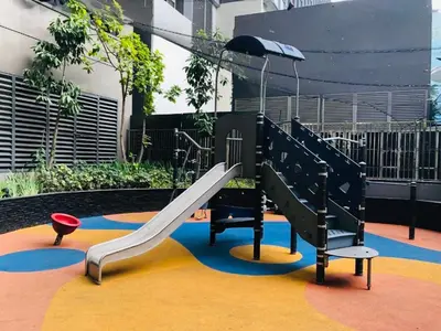 a playground with a slide and an umbrella at The Gramercy Residences NEW Sleek 1BR Suite, 600mbps Wifi, Netflix & FREE Amenities in Manila