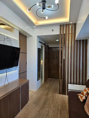 a living room with a flat screen tv on a wall at Cozy Two-Bedroom Suite, Coast Residences, Pasay in Manila