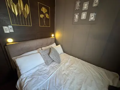 a bed in a bedroom with two pillows on it at Air Residences Luxury Condo with Balcony Netflix Wifi in Manila