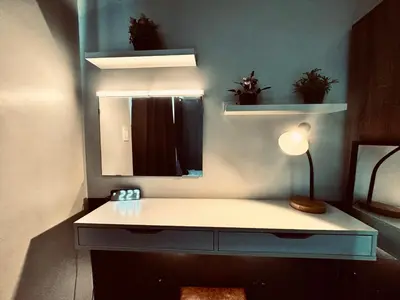a room with a desk with a mirror and a lamp at Air Residences Luxury Condo with Balcony Netflix Wifi in Manila