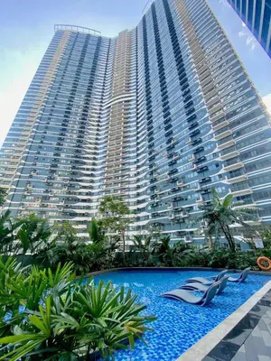 a large building with a swimming pool in front of a building at Air Residences Luxury Condo with Balcony Netflix Wifi in Manila
