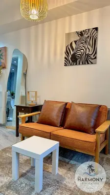 a living room with a couch and a zebra picture on the wall at Azure Residences Staycation - Bahamas tower in Manila