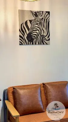 a picture of a zebra on the wall above a couch at Azure Residences Staycation - Bahamas tower in Manila